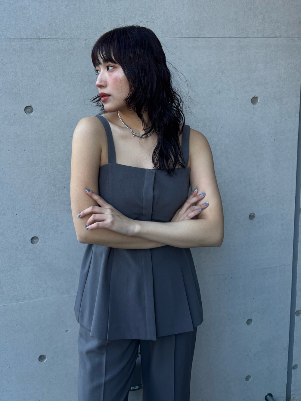 グレー系のベスト、グレー系のスラックスを着用したレディースの冬コーディネートの3枚目の写真