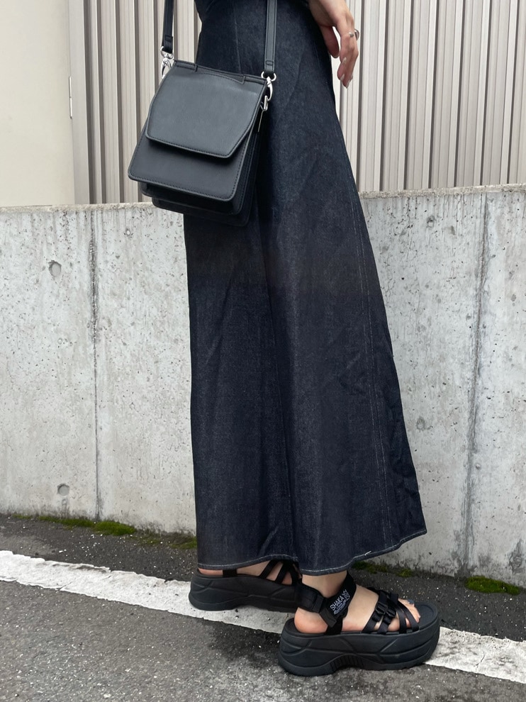 ブラック系のワンピース、ブラック系のサンダル、ブラック系のハンドバッグを着用したレディースの春コーディネートの5枚目の写真