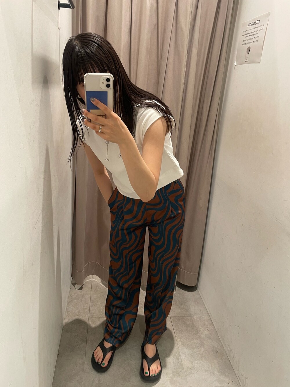 ブルー系のスラックス、ホワイト系のタンクトップを着用したレディースの夏コーディネートの2枚目の写真