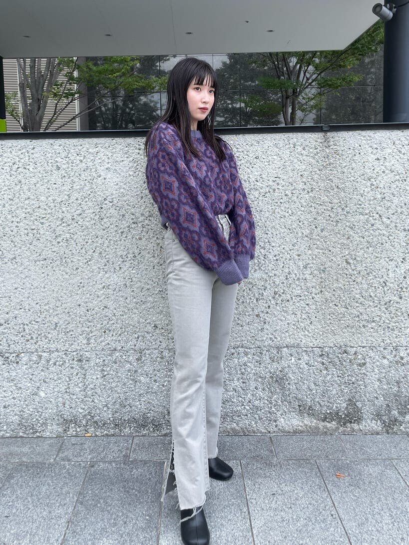 グレー系のデニムパンツ、パープル系のニット/セーターを着用したレディースの冬コーディネートの2枚目の写真