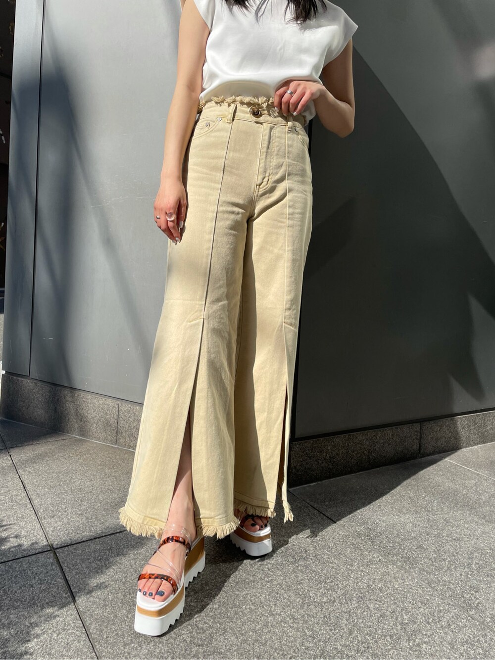 ホワイト系のTシャツ/カットソー、イエロー系のその他パンツ、ホワイト系のサンダルを着用したレディースの春コーディネートの5枚目の写真