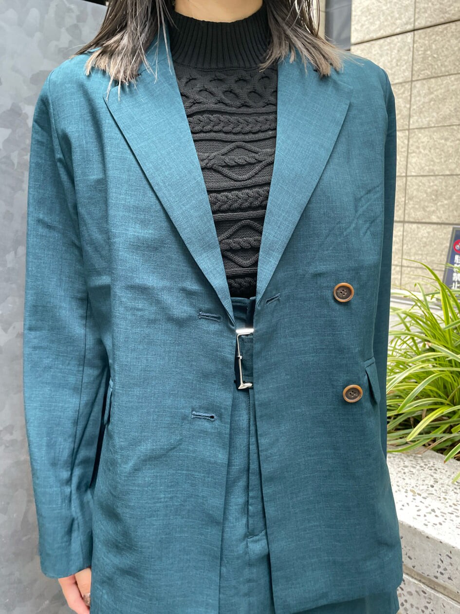 グリーン系のテーラードジャケット、グリーン系のスカート、ブラック系のニット/セーターを着用したレディースの夏コーディネートの5枚目の写真