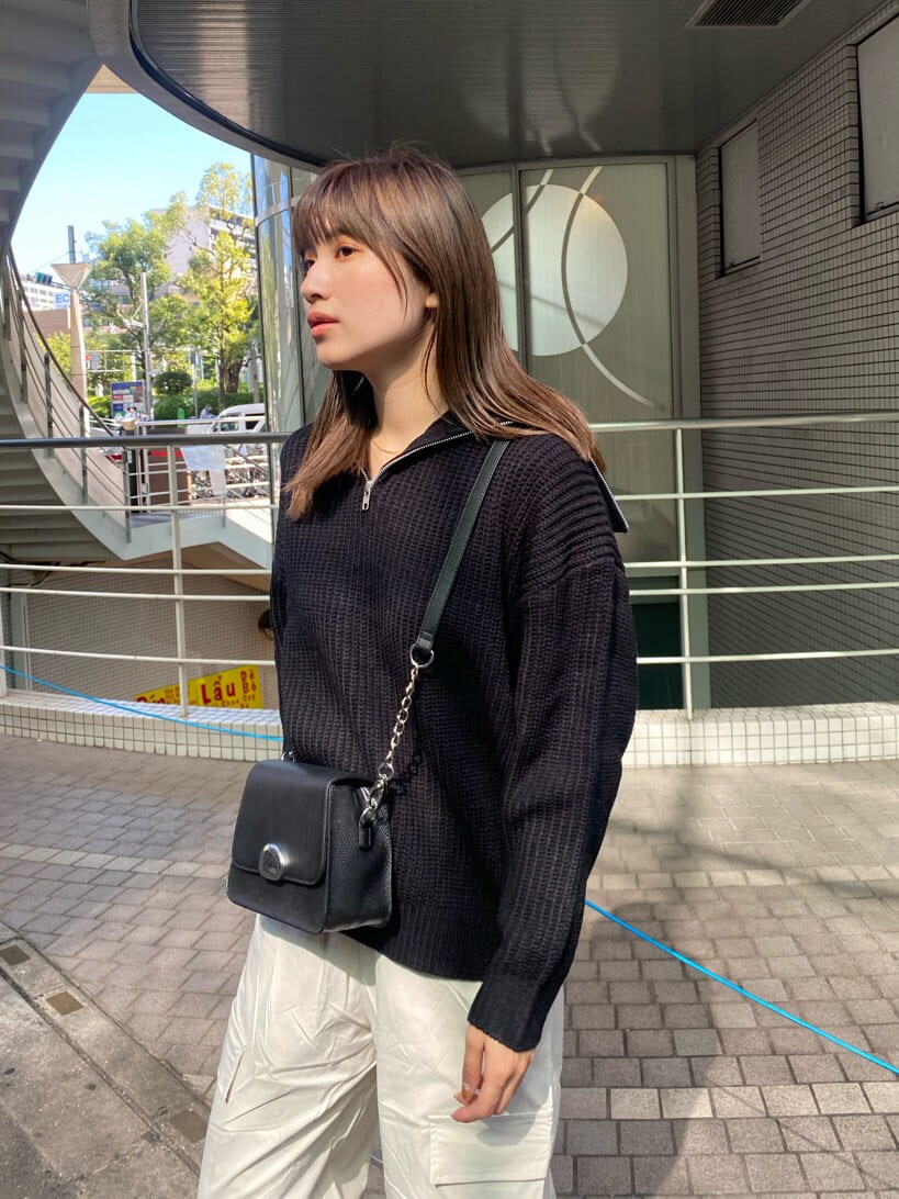 ブラック系のブーツ、ブラック系のニット/セーター、ブラック系のショルダーバッグを着用したレディースの秋コーディネートの4枚目の写真