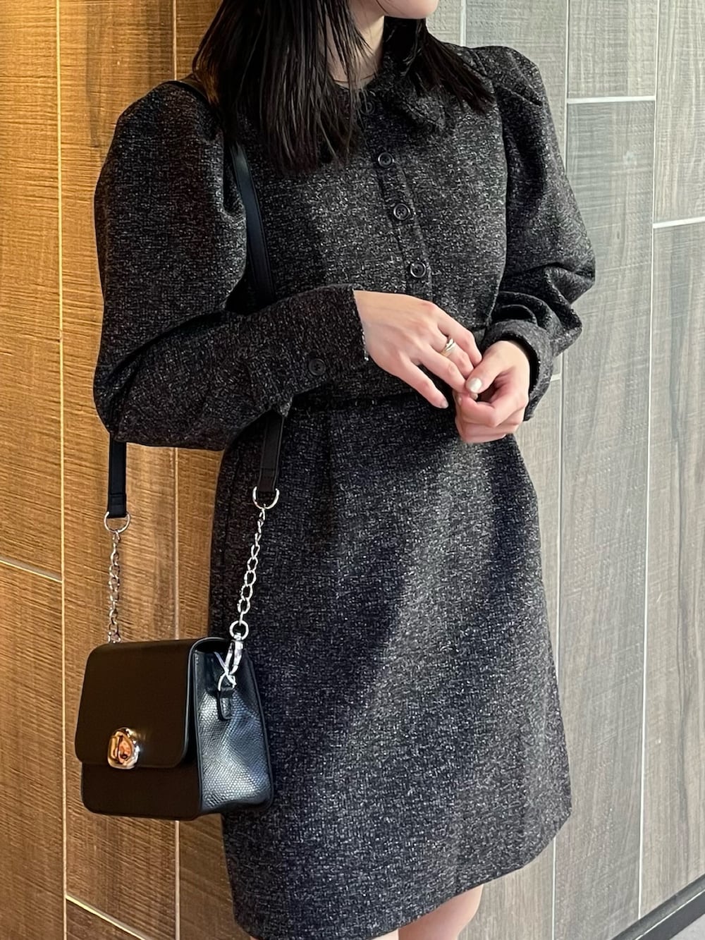 ブラック系のワンピース、ブラック系のブーツ、ブラック系のショルダーバッグを着用したレディースの冬コーディネートの6枚目の写真