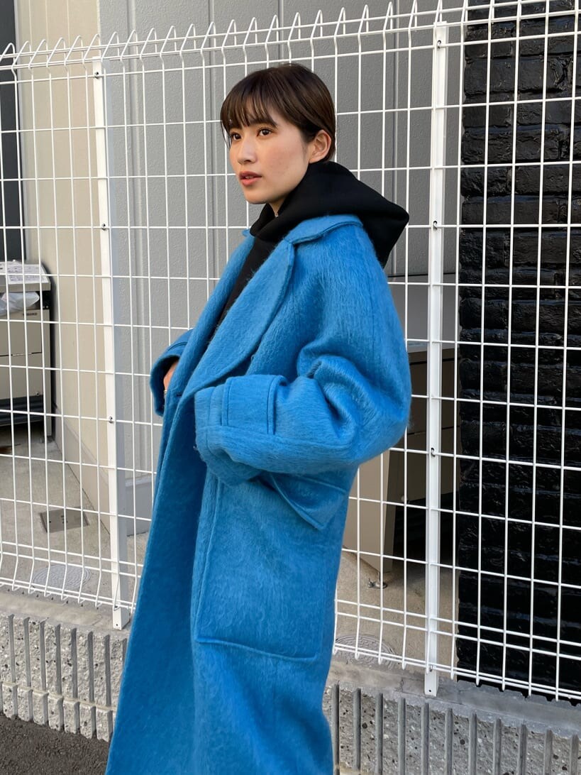 ブラック系のブーツ、ブラック系のパーカー、ブルー系のチェスターコートを着用したレディースの秋コーディネートの4枚目の写真