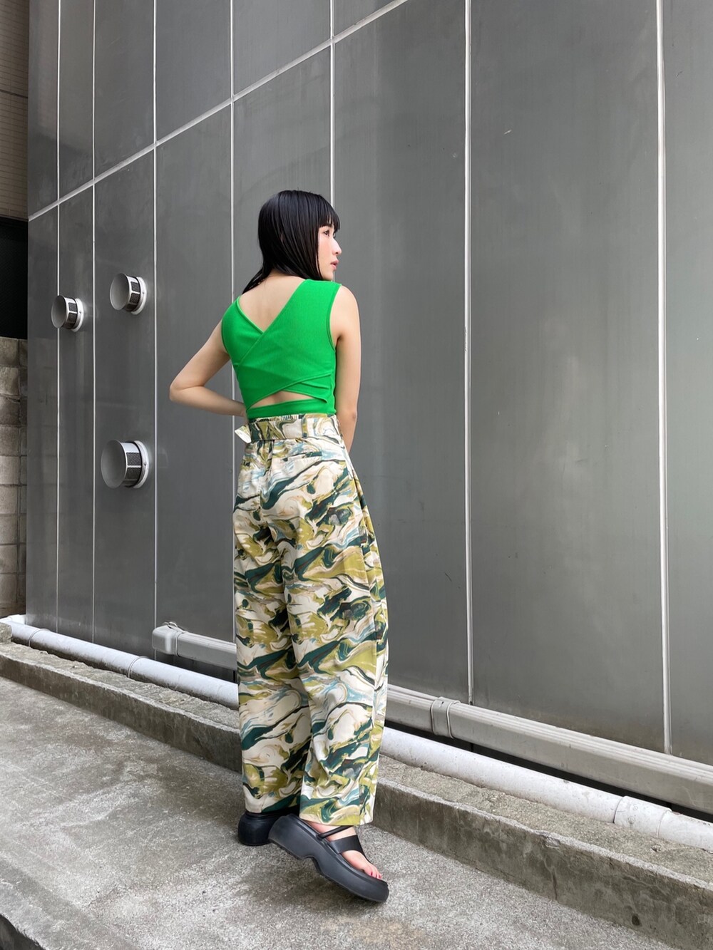 ブラック系のサンダル、グリーン系のスラックス、グリーン系のタンクトップを着用したレディースの春コーディネートの2枚目の写真
