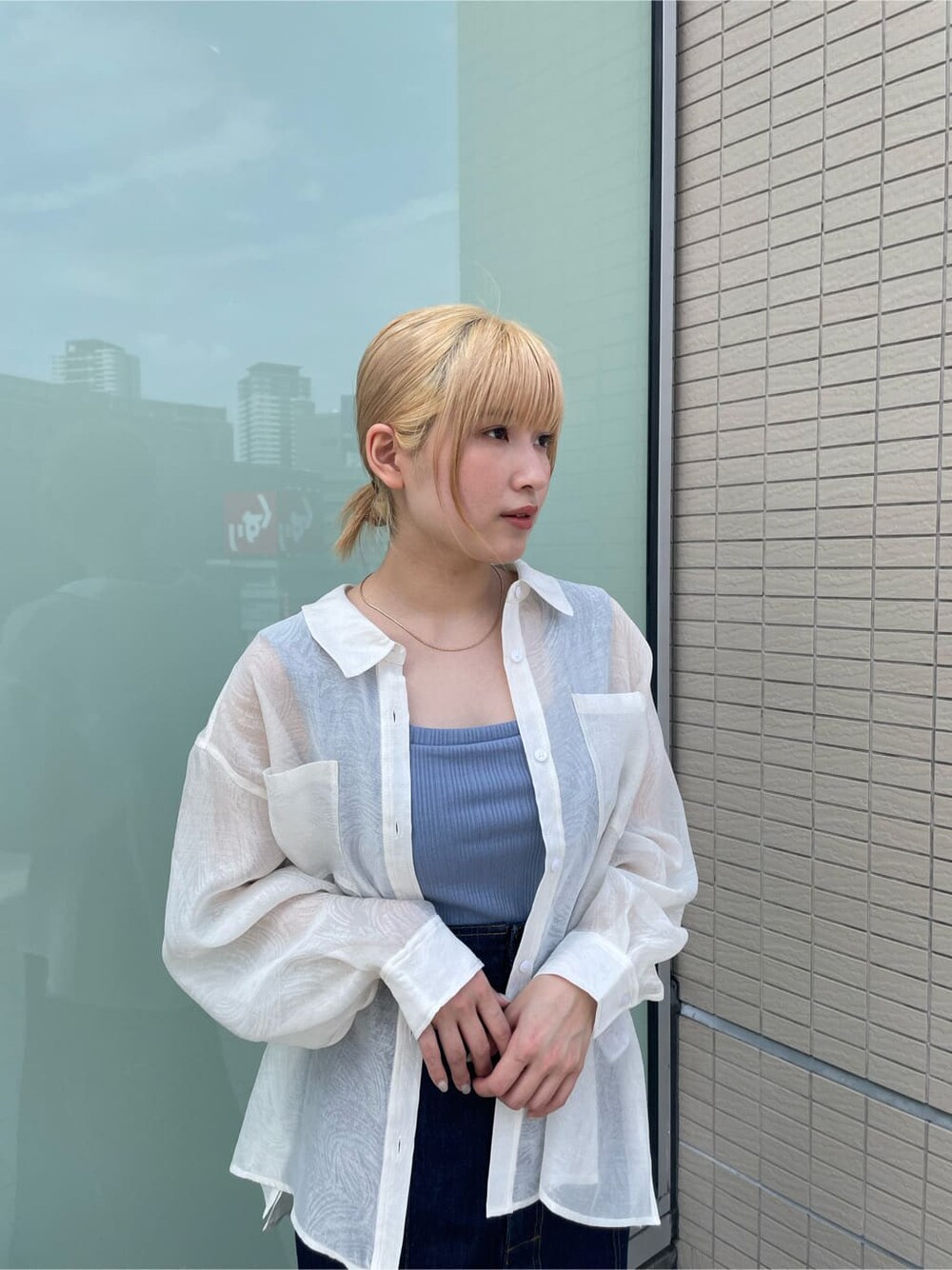 ブルー系のタンクトップ、ブルー系のデニムスカート、ホワイト系のサンダルを着用したレディースの春コーディネートの5枚目の写真