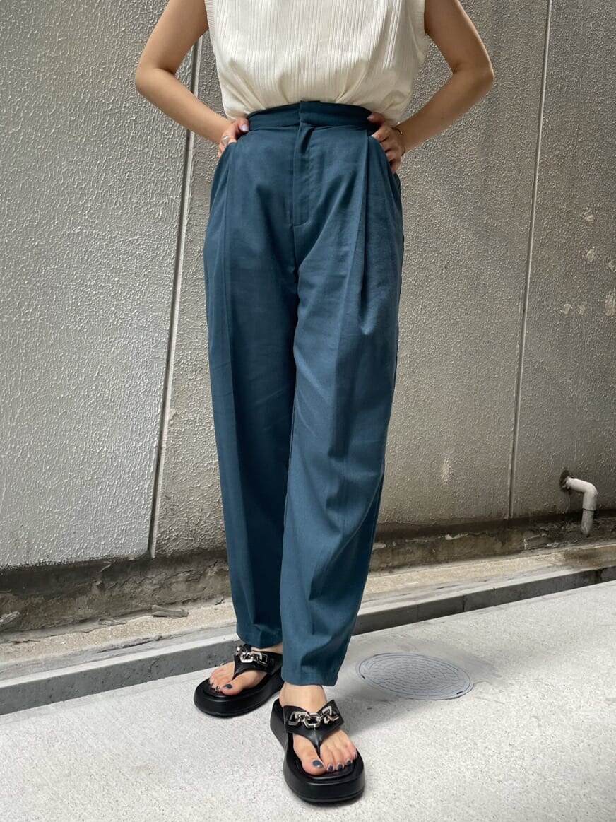 グリーン系のスラックス、ブラック系のサンダル、ホワイト系のTシャツ/カットソーを着用したレディースの夏コーディネートの5枚目の写真