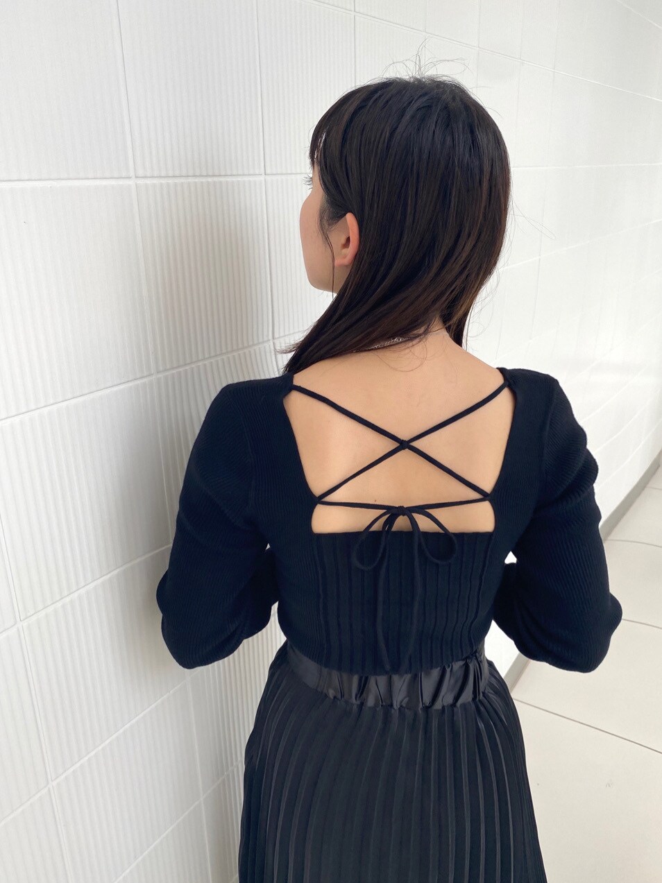 ブラック系のパンプス、ブラック系のニット/セーター、ブラック系のスカートを着用したレディースの春コーディネートの2枚目の写真