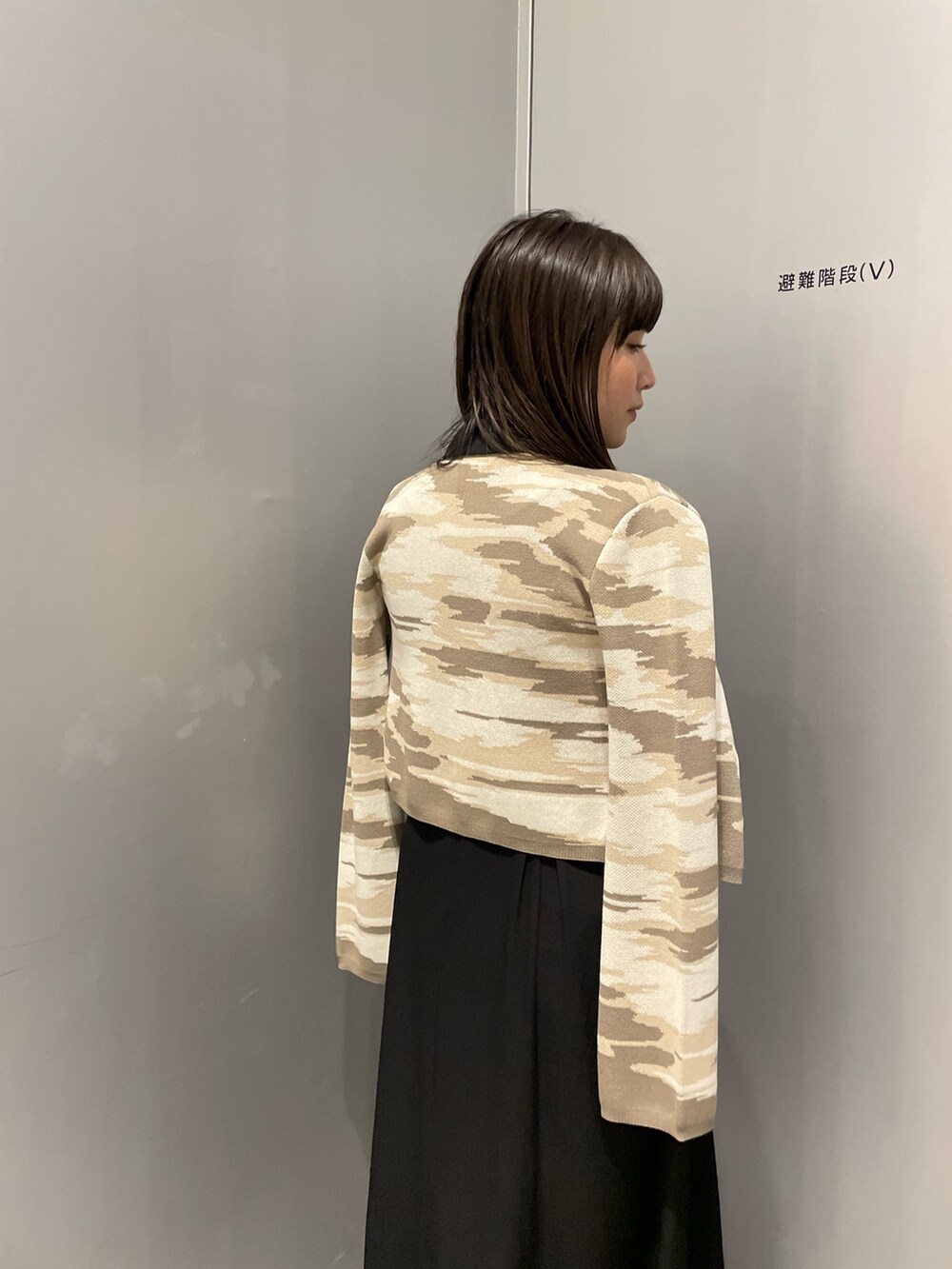 ベージュ系のカーディガン/ボレロ、ブラック系のワンピースを着用したレディースの冬コーディネートの5枚目の写真