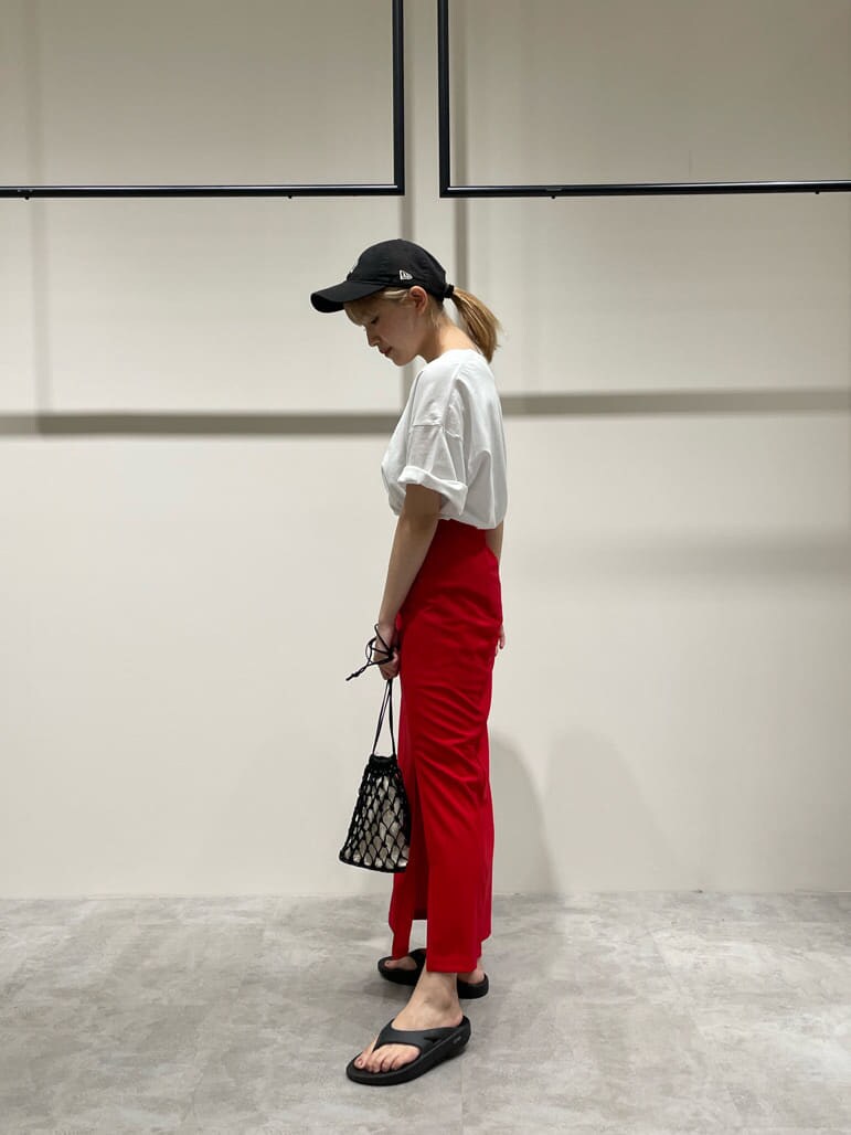 ブラック系のハンドバッグ、ホワイト系のTシャツ/カットソー、レッド系のスカートを着用したレディースの夏コーディネートの3枚目の写真