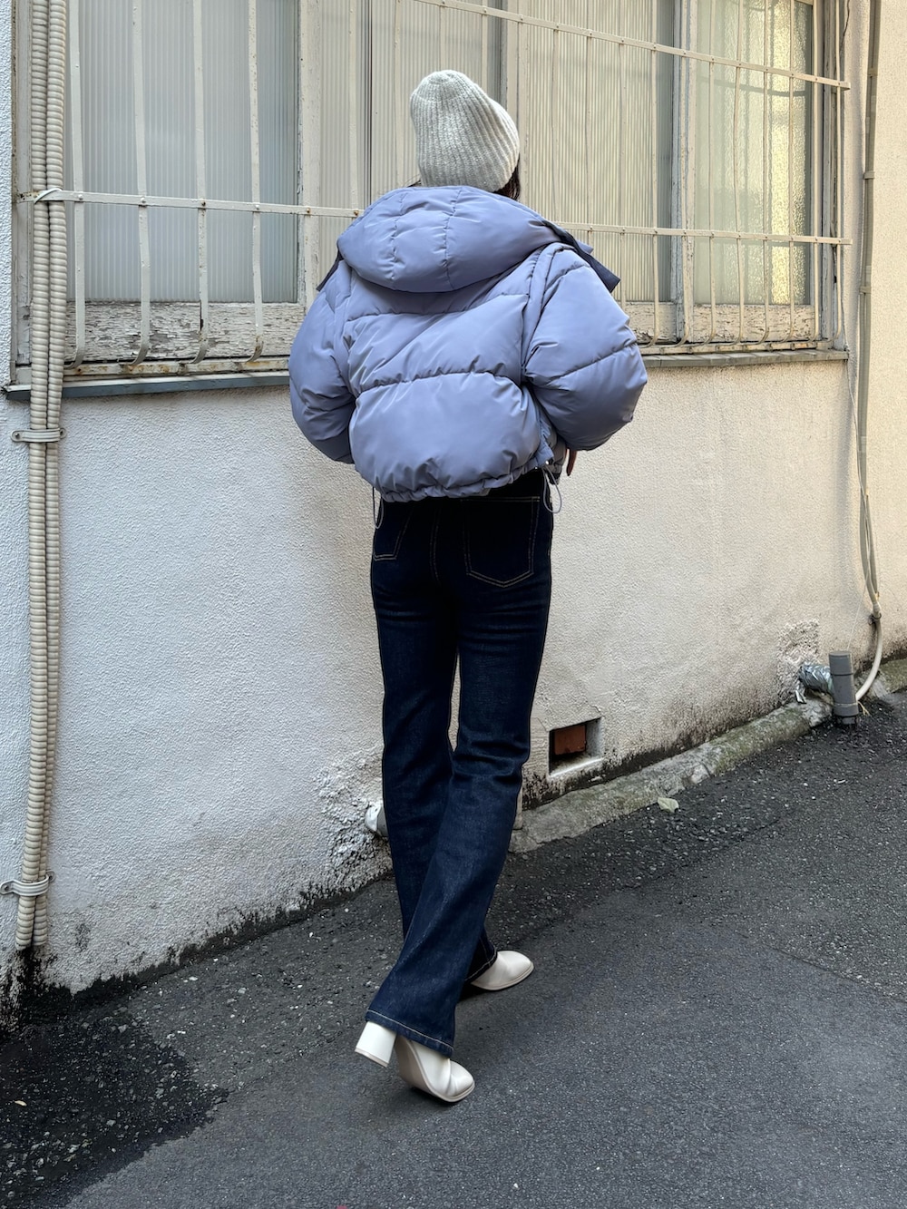 パープル系のニット/セーター、ブルー系のブルゾン、ブルー系のデニムパンツを着用したレディースの秋コーディネートの2枚目の写真