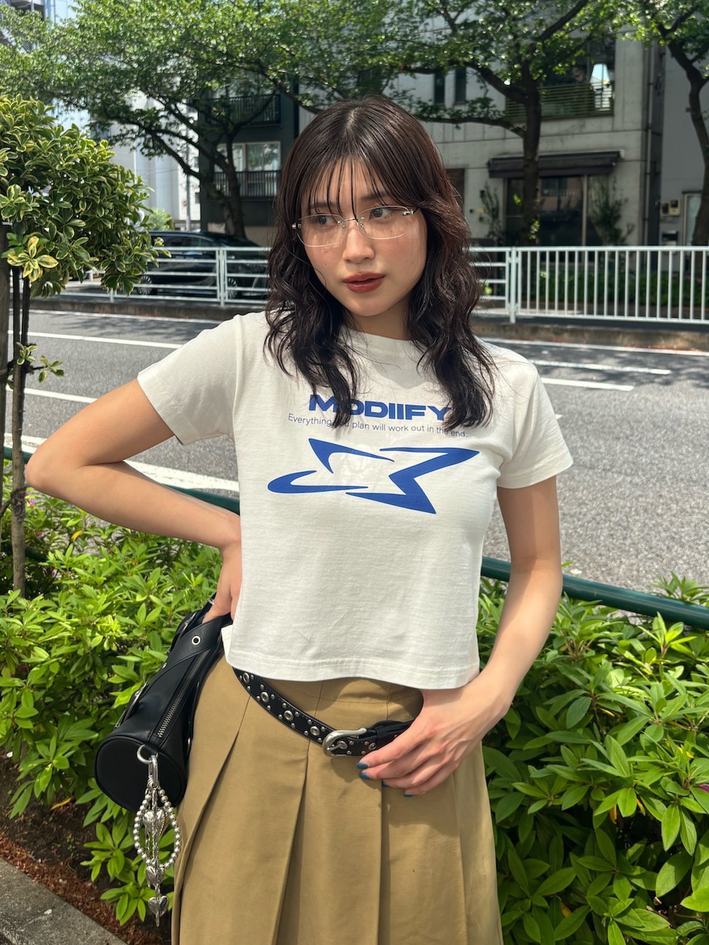 ホワイト系のTシャツ/カットソー、ブラック系のハンドバッグ、ブラック系のベルトを着用したレディースの春コーディネートの2枚目の写真