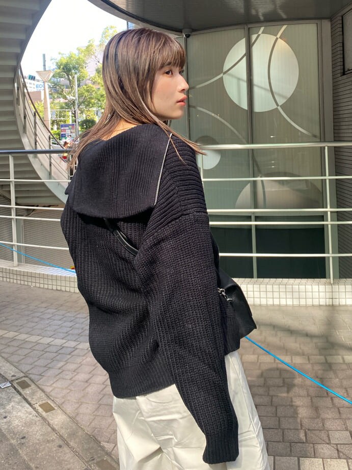 ブラック系のブーツ、ブラック系のニット/セーター、ブラック系のショルダーバッグを着用したレディースの秋コーディネートの5枚目の写真