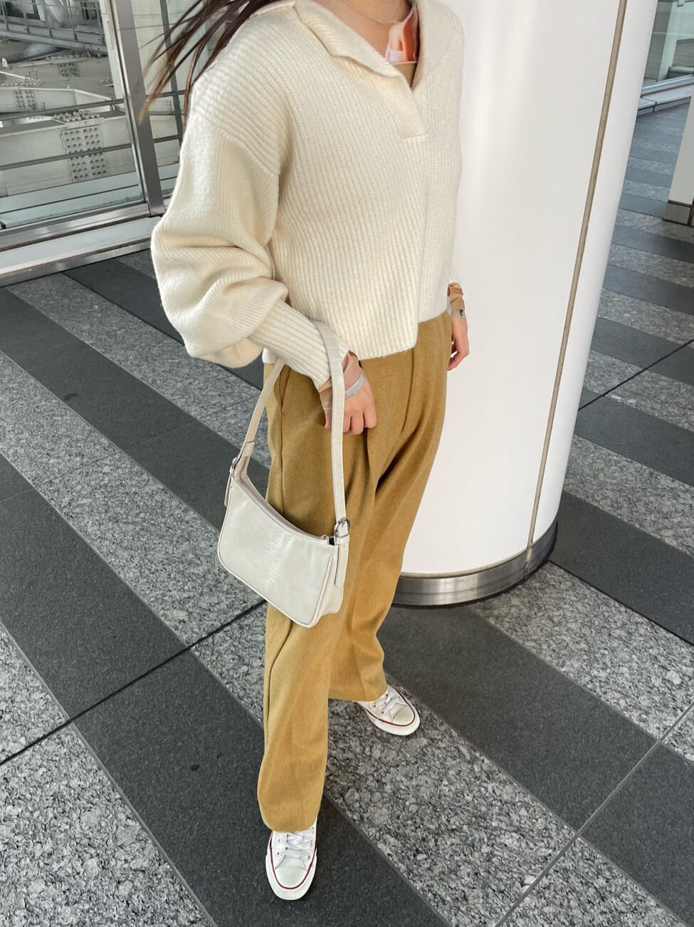 ホワイト系のハンドバッグ、イエロー系のその他パンツ、ホワイト系のニット/セーターを着用したレディースの冬コーディネートの3枚目の写真