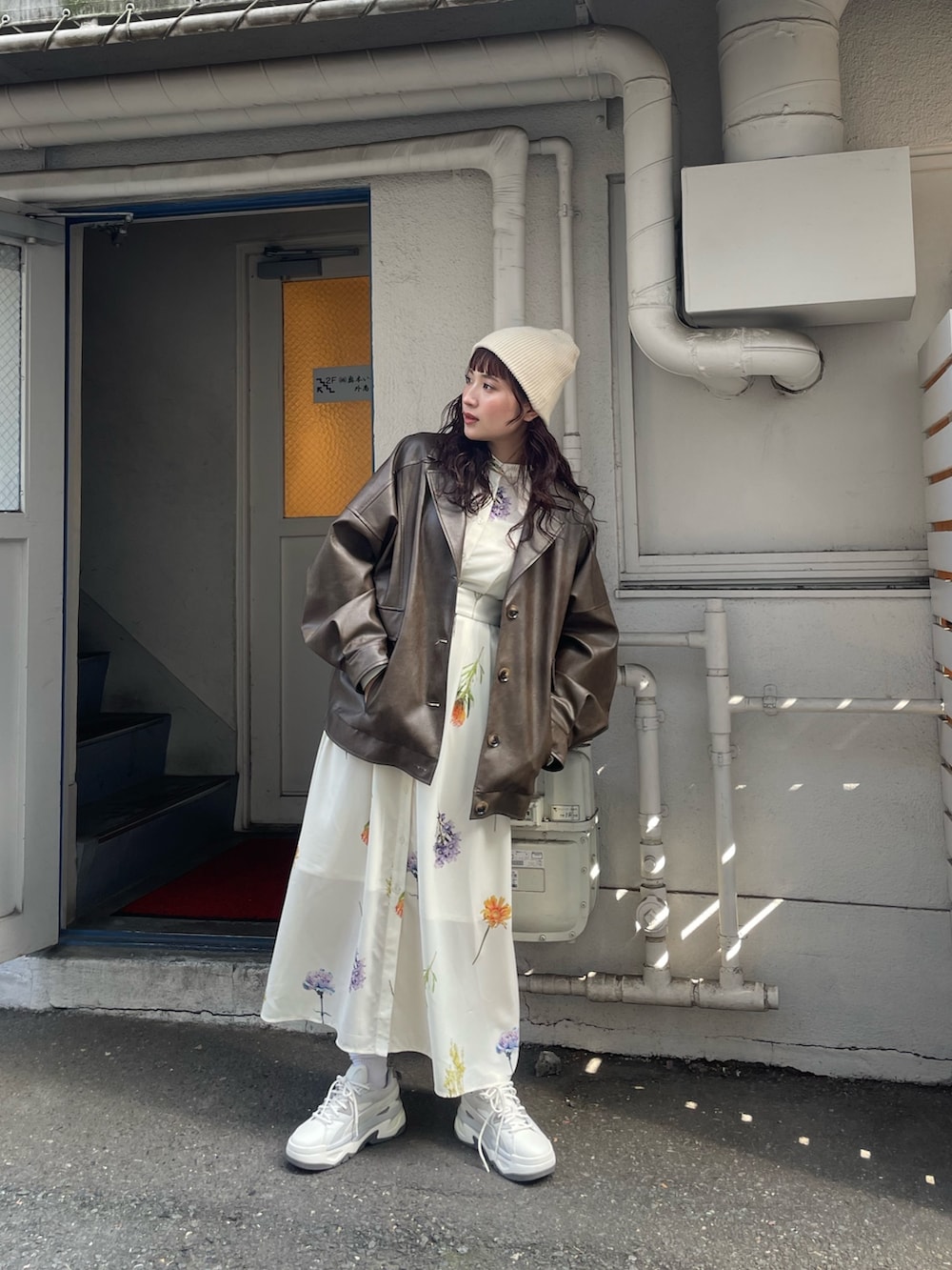 ホワイト系のワンピース、ブラウン系のブルゾンを着用したレディースの冬コーディネートの2枚目の写真