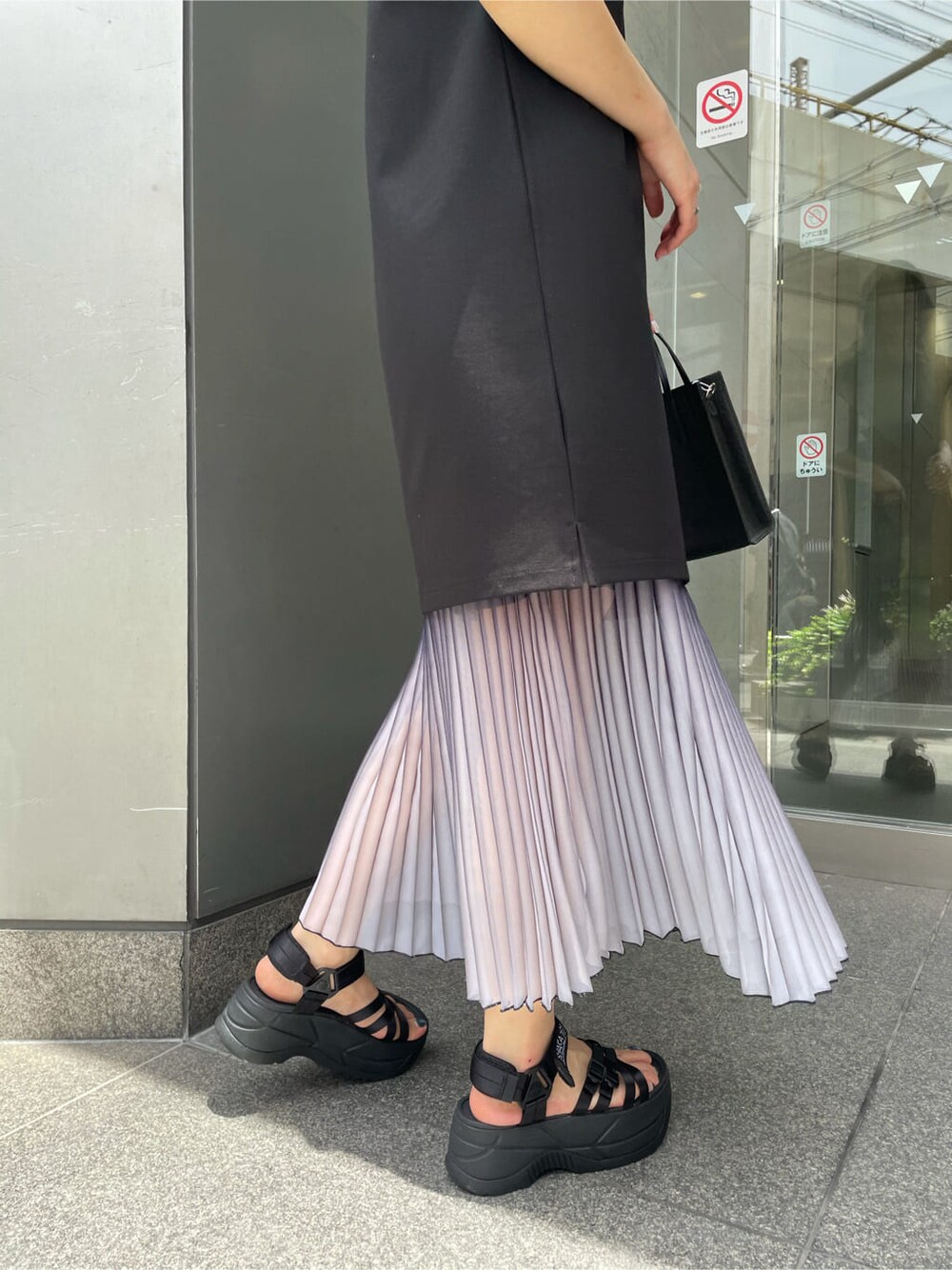 ブルー系のスカート、ブラック系のワンピース、ブラック系のサンダルを着用したレディースの夏コーディネートの7枚目の写真