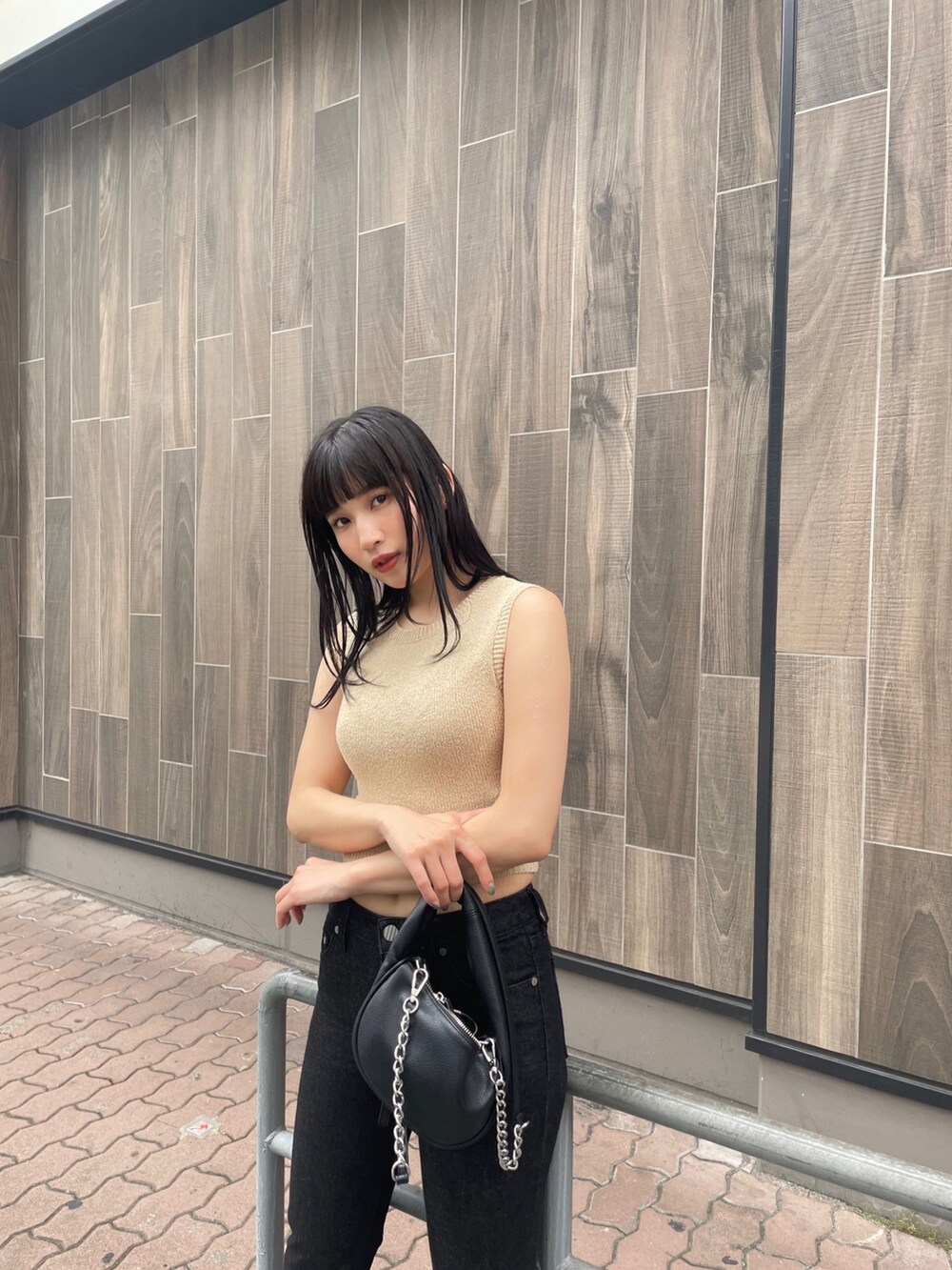 ホワイト系のタンクトップ、ブラック系のデニムパンツ、ブラック系のサンダルを着用したレディースの春コーディネートの2枚目の写真