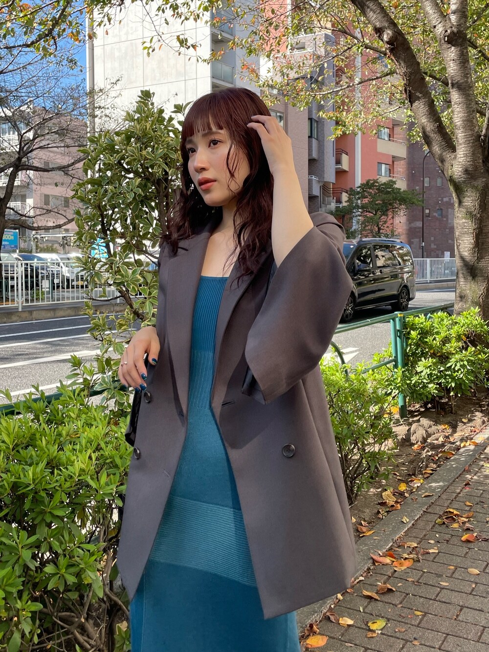 グレー系のテーラードジャケット、ブルー系のワンピースを着用したレディースの冬コーディネートの3枚目の写真