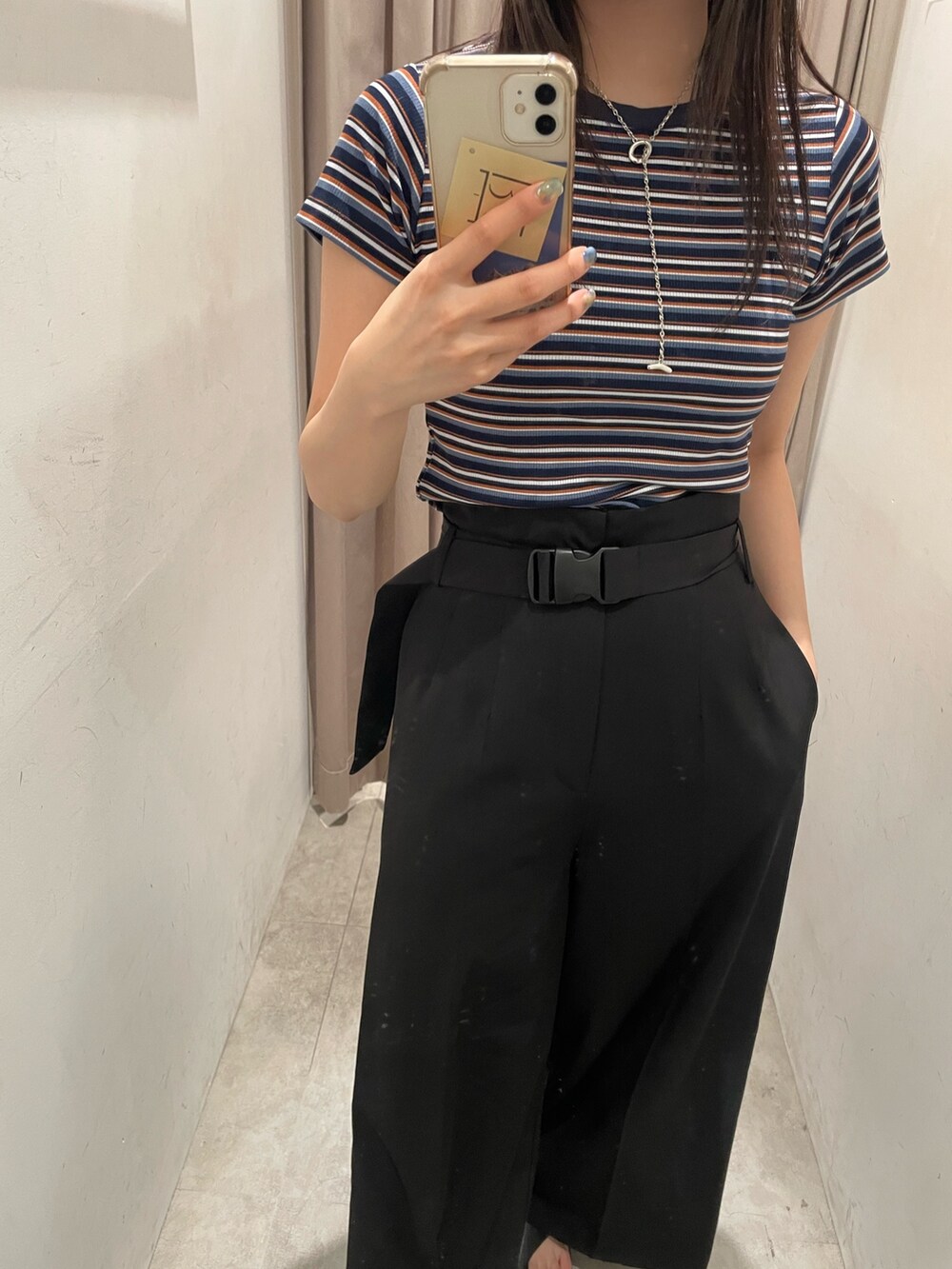 ブルー系のTシャツ/カットソー、ブラック系のスラックス、ブラック系のサンダルを着用したレディースの春コーディネートの4枚目の写真