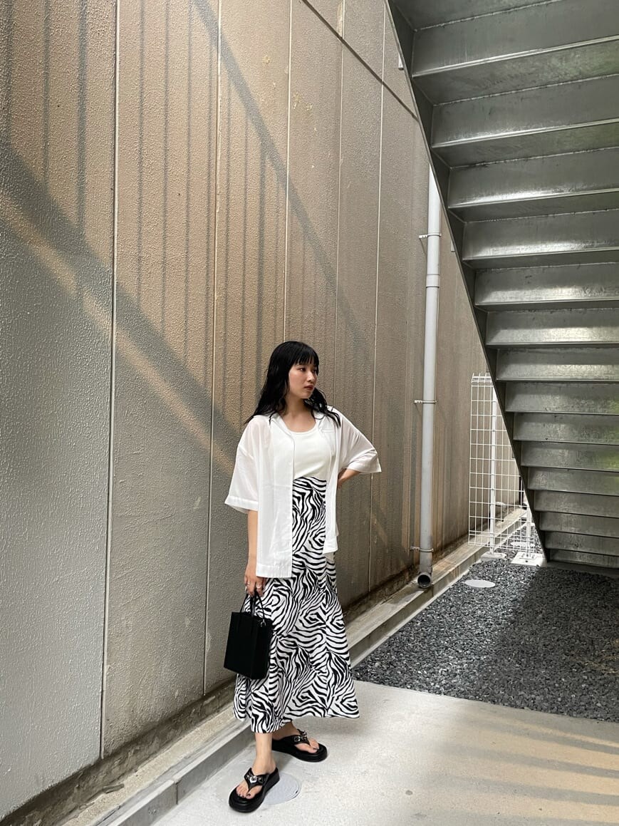 ホワイト系のTシャツ/カットソー、ブラック系のサンダル、その他のスカートを着用したレディースの夏コーディネートの2枚目の写真