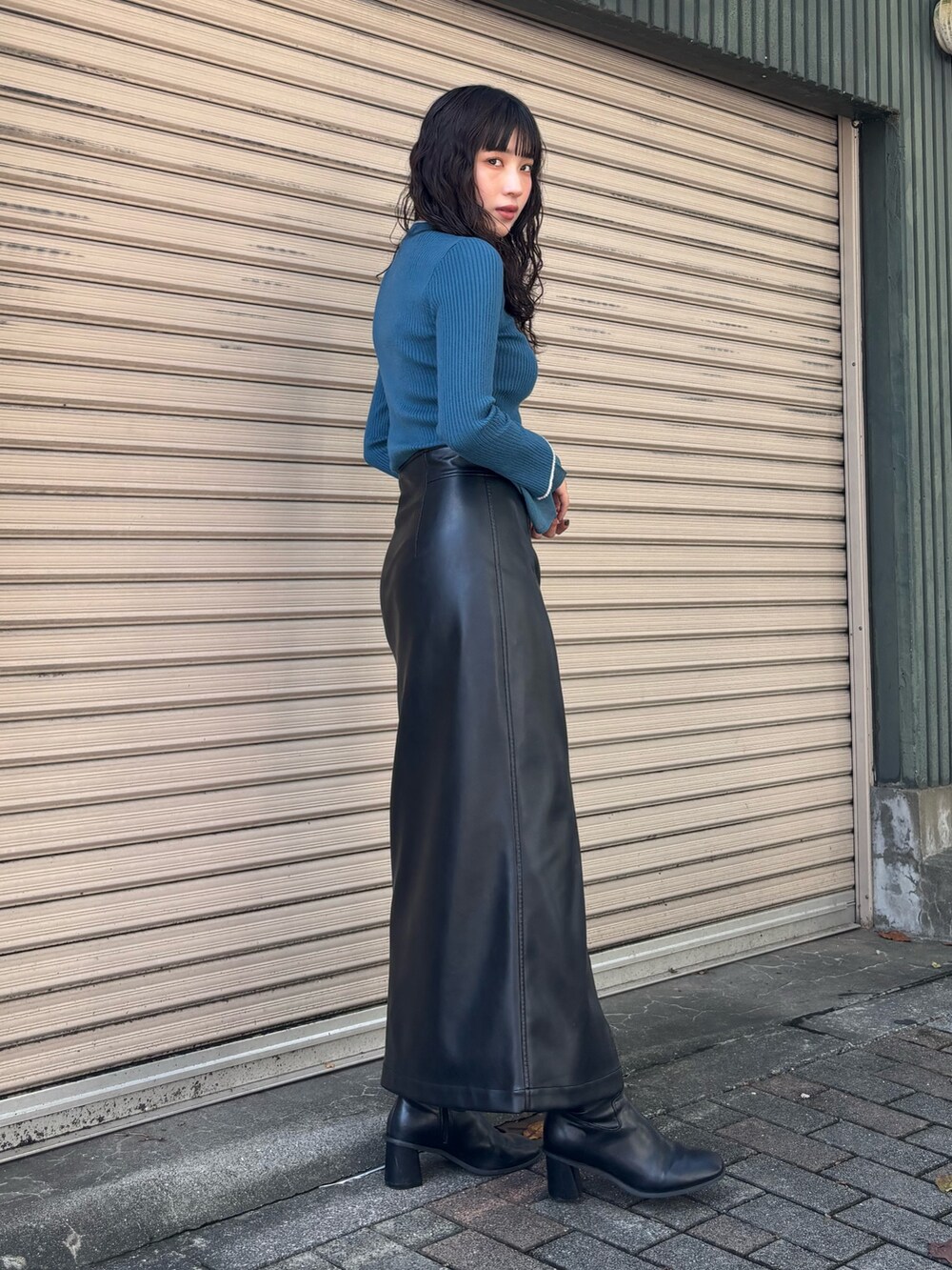 ブルー系のニット/セーター、ブラック系のスカートを着用したレディースの秋コーディネートの2枚目の写真