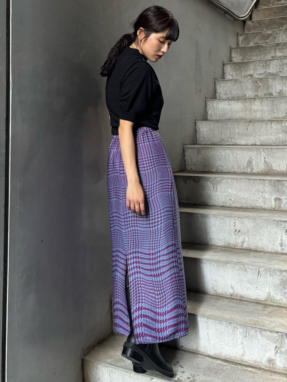 ブラック系のニット/セーター、パープル系のスカートを着用したレディースの夏コーディネートの2枚目の写真