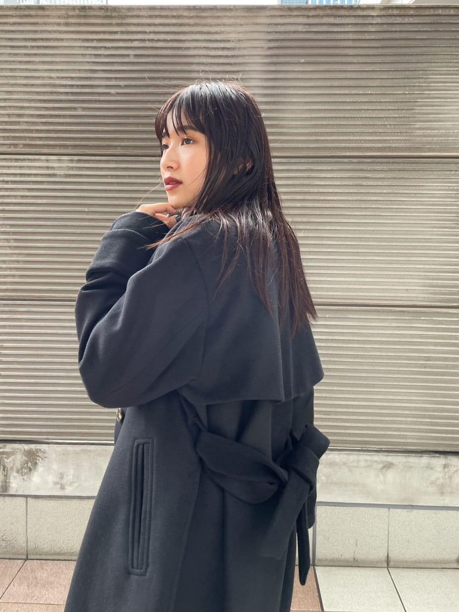 ベージュ系のニット/セーター、ブラック系のダウンジャケット/コート、ブルー系のスカートを着用したレディースの秋コーディネートの2枚目の写真