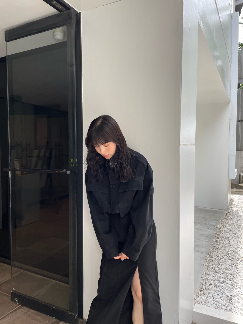 ブラック系のデニムジャケット、ブラック系のスカートを着用したレディースの夏コーディネートの2枚目の写真