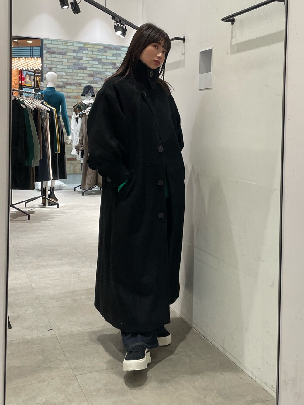 ブラック系のダウンジャケット/コート、グリーン系のニット/セーターを着用したレディースの冬コーディネートの2枚目の写真