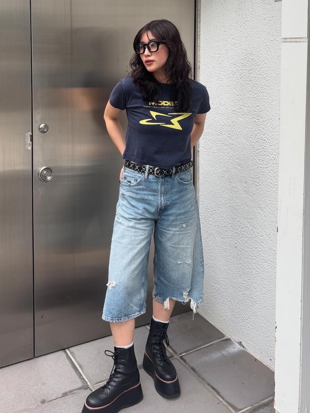 ブルー系のTシャツ/カットソー、ブラック系のブーツ、ブラック系のベルトを着用したレディースの春コーディネートの2枚目の写真