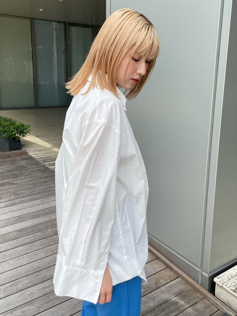 ベージュ系のスニーカー、ホワイト系のシャツ/ブラウス、ブルー系のスラックスを着用したレディースの春コーディネートの5枚目の写真