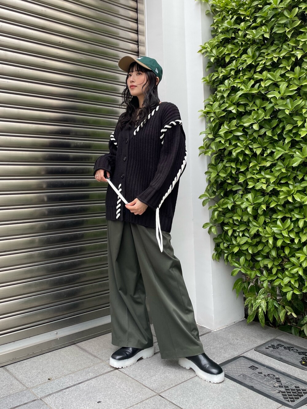 ベージュ系のスラックス、ブラック系のカーディガン/ボレロ、グリーン系のキャップを着用したレディースの秋コーディネートの5枚目の写真