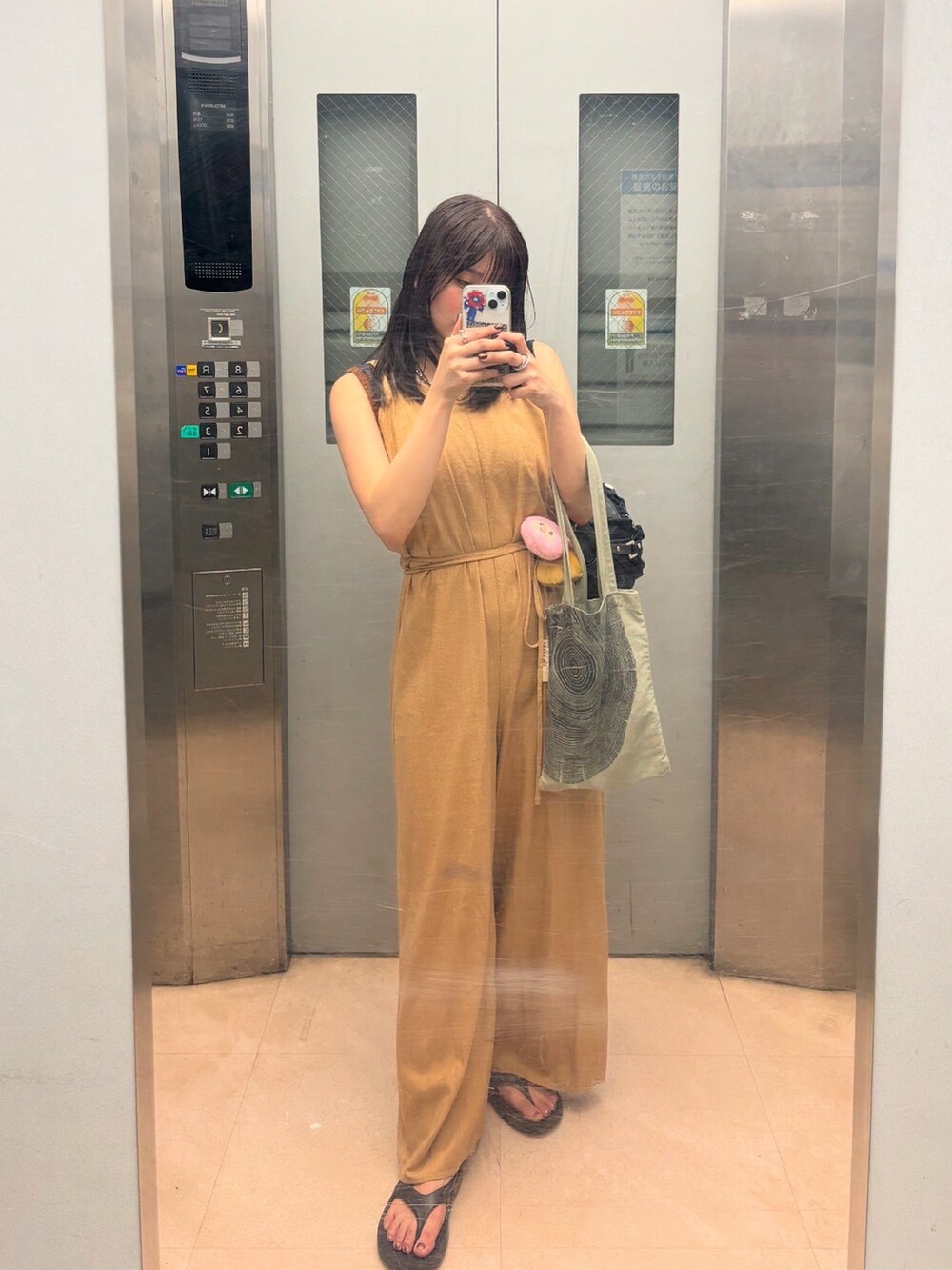 ブラウン系のニット/セーターを着用したレディースの夏コーディネートの3枚目の写真
