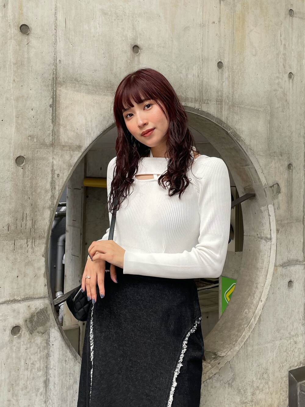 ホワイト系のニット/セーター、ブラック系のデニムスカートを着用したレディースの冬コーディネートの4枚目の写真