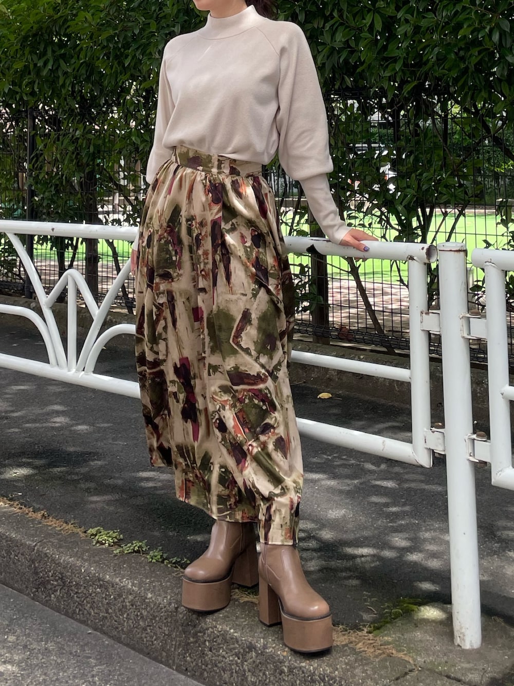 ホワイト系のニット/セーター、グリーン系のスカートを着用したレディースの夏コーディネートの3枚目の写真