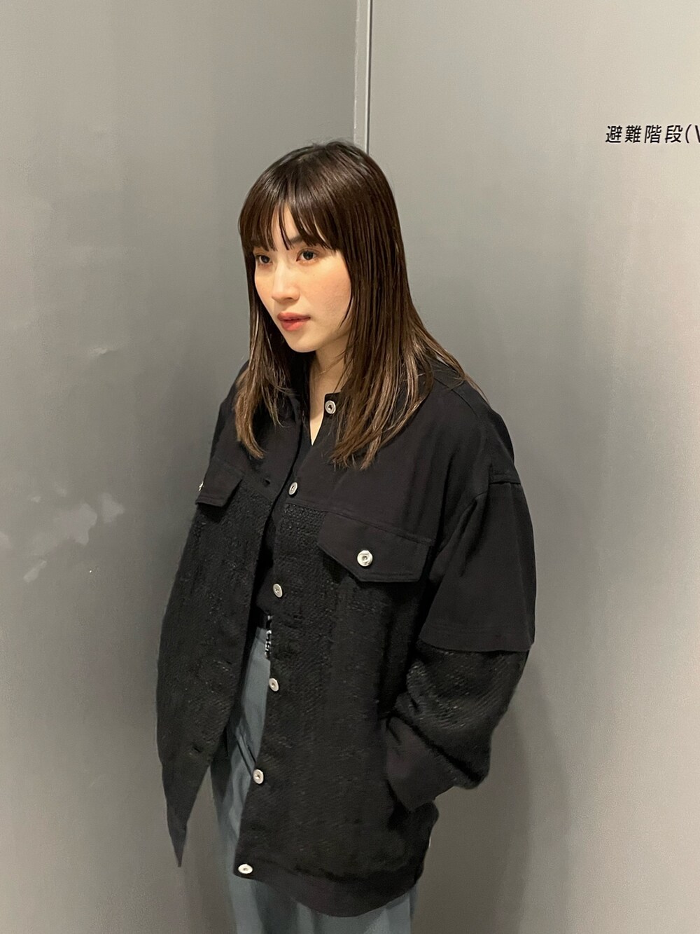 ブラック系のブルゾン、ブルー系のスラックスを着用したレディースの冬コーディネートの5枚目の写真
