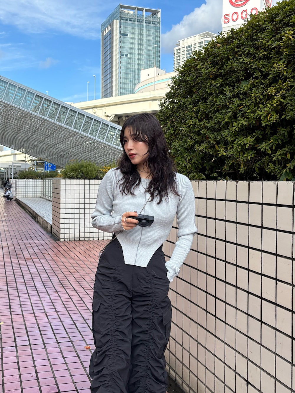 シルバー系のショルダーバッグ、ブラック系のデニムパンツ、グレー系のニット/セーターを着用したレディースの春コーディネートの5枚目の写真