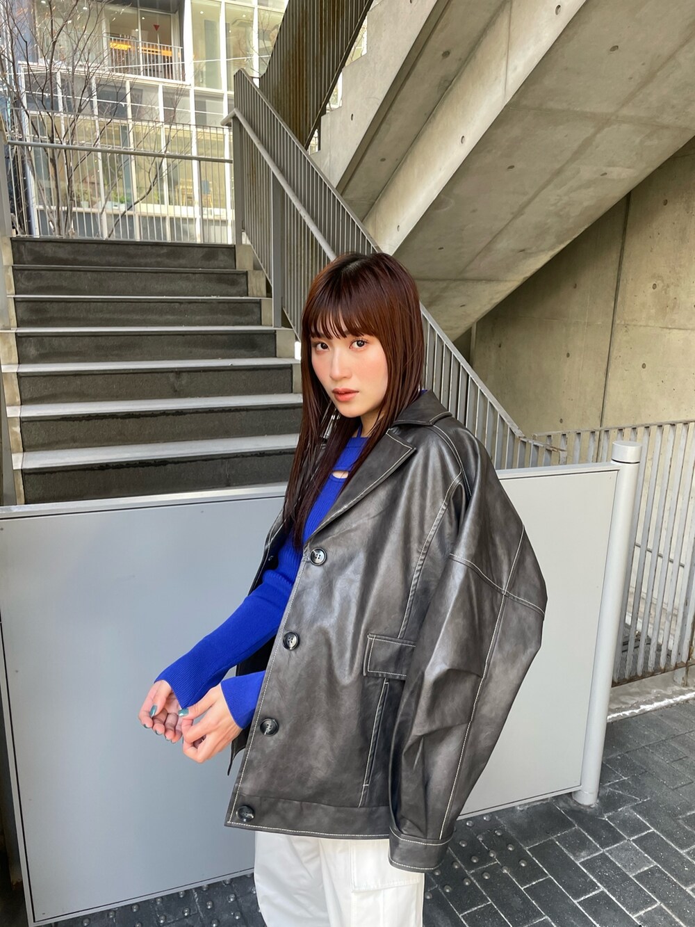 グレー系のブルゾン、ブルー系のニット/セーター、ホワイト系のカーゴパンツを着用したレディースの冬コーディネートの5枚目の写真