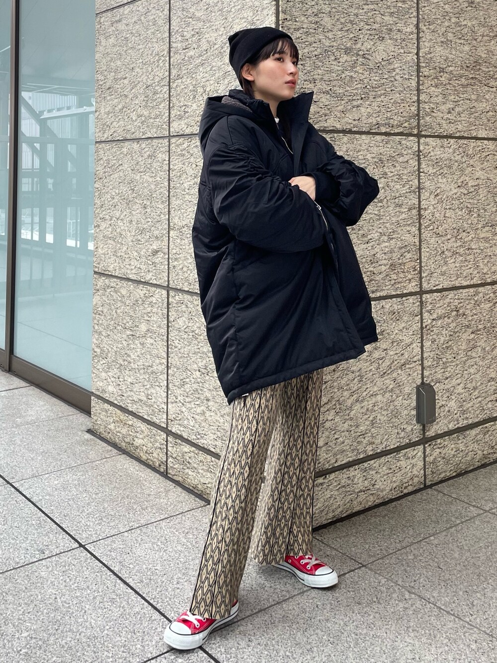 ブルー系のニット/セーター、ブラック系のブルゾンを着用したレディースの秋コーディネートの2枚目の写真