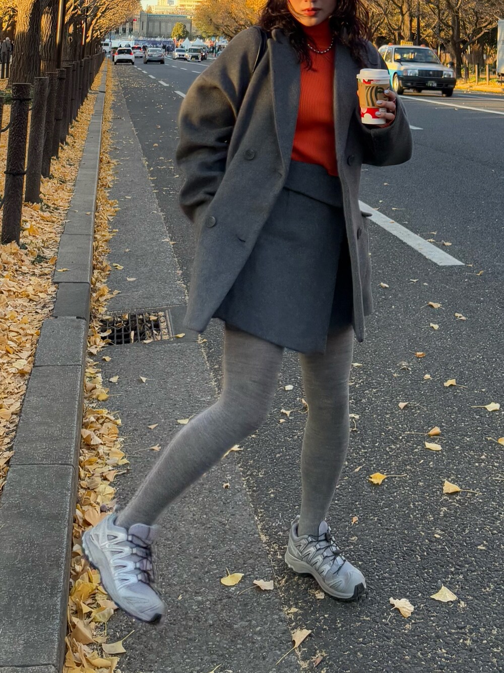 グレー系のテーラードジャケット、グレー系のスカート、ブラック系のボストンバッグを着用したレディースの冬コーディネートの2枚目の写真