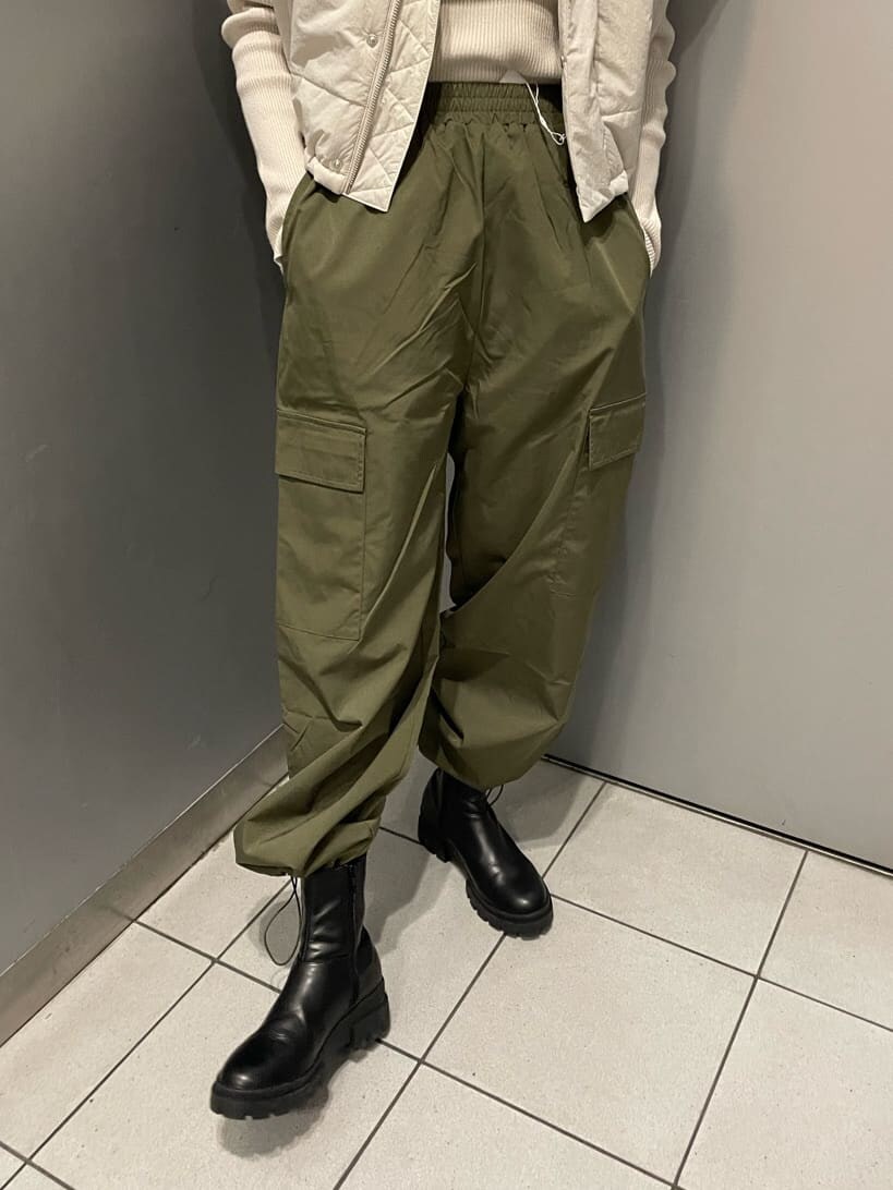 ホワイト系のダウンベスト、ブラック系のブーツ、ホワイト系のニット/セーターを着用したレディースの秋コーディネートの7枚目の写真