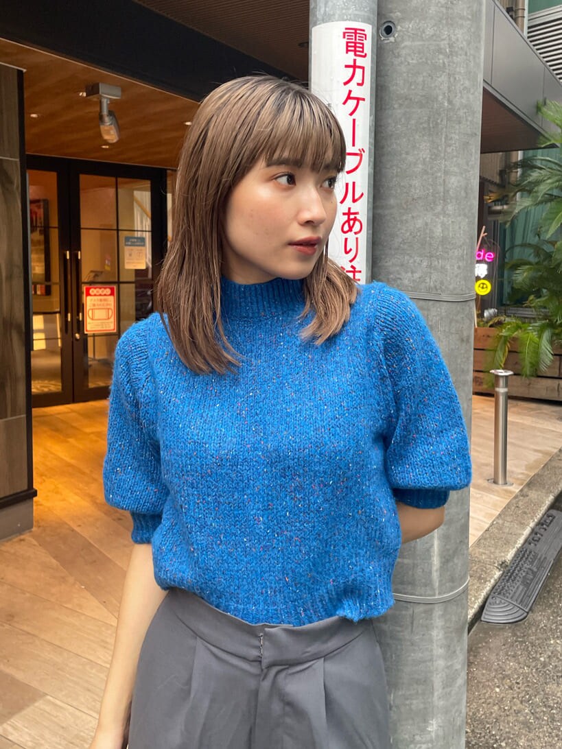 ブルー系のニット/セーター、ブルー系のトレンチコート、グレー系のスラックスを着用したレディースの秋コーディネートの6枚目の写真