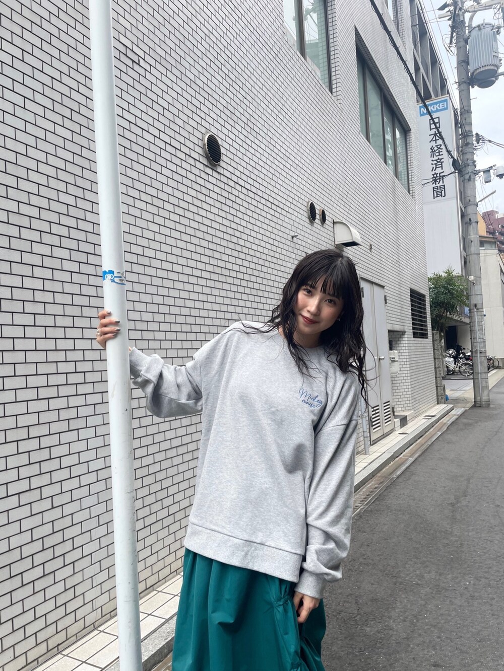 グリーン系のスカート、グレー系のスウェットを着用したレディースの秋コーディネートの3枚目の写真