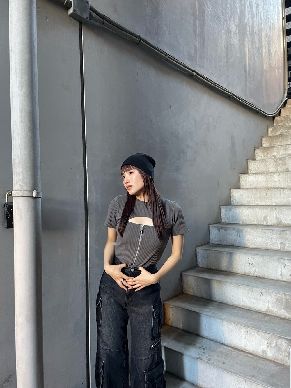 グレー系のTシャツ/カットソー、ブラック系のデニムパンツを着用したレディースの冬コーディネートの2枚目の写真