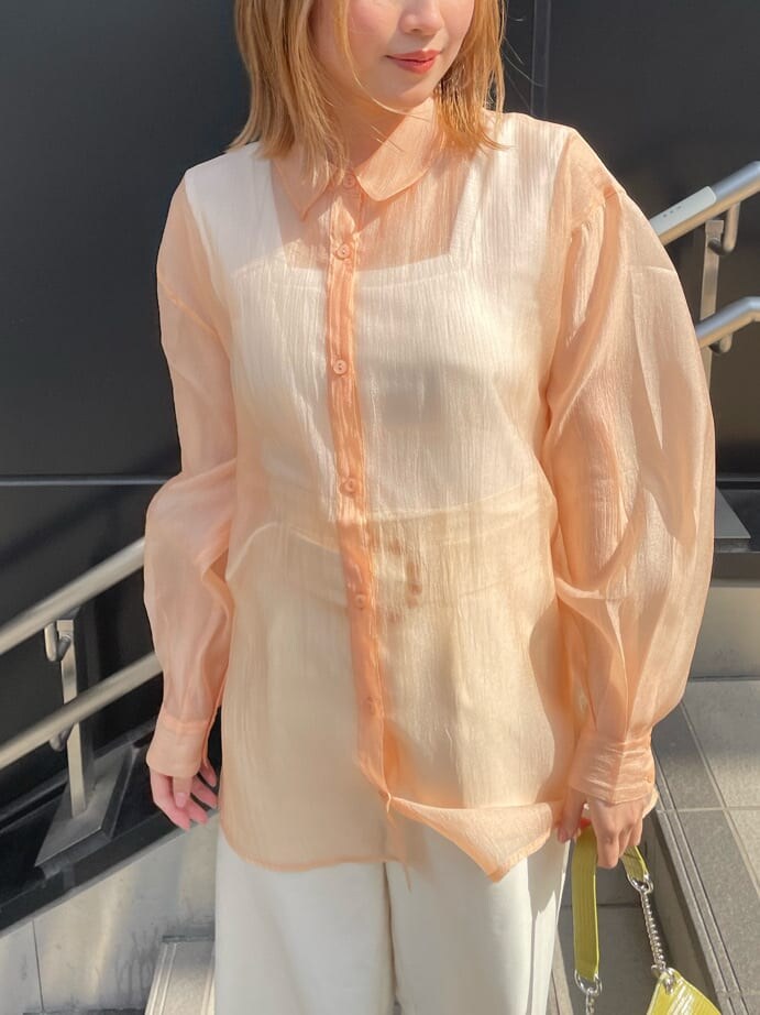 ホワイト系のスラックス、ホワイト系のハンドバッグ、ホワイト系のタンクトップを着用したレディースの春コーディネートの4枚目の写真