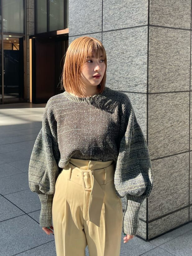 ホワイト系のブーツ、イエロー系のスラックス、ブラウン系のニット/セーターを着用したレディースの冬コーディネートの3枚目の写真