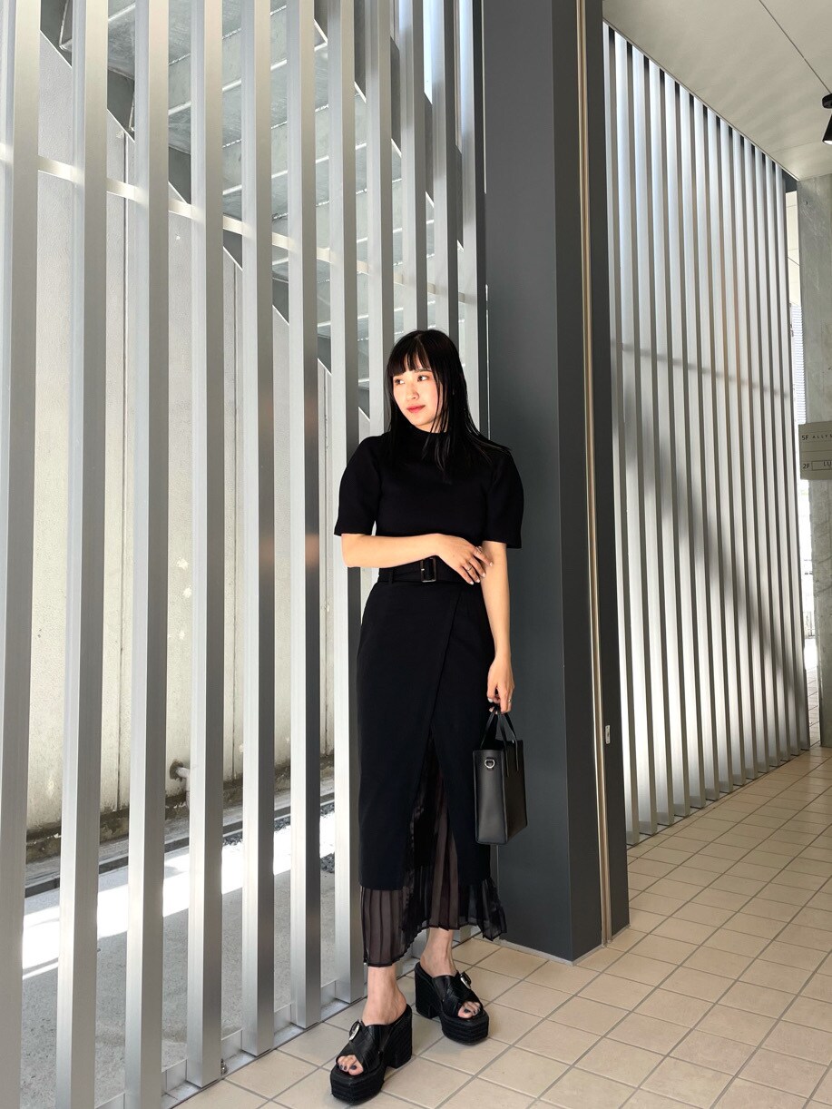 ブラック系のスカート、ブラック系のサンダル、ブラック系のニット/セーターを着用したレディースの春コーディネートの2枚目の写真