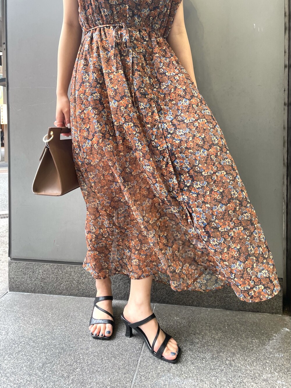 ブラウン系のワンピース、ブラック系のサンダル、ブラウン系のハンドバッグを着用したレディースの春コーディネートの5枚目の写真