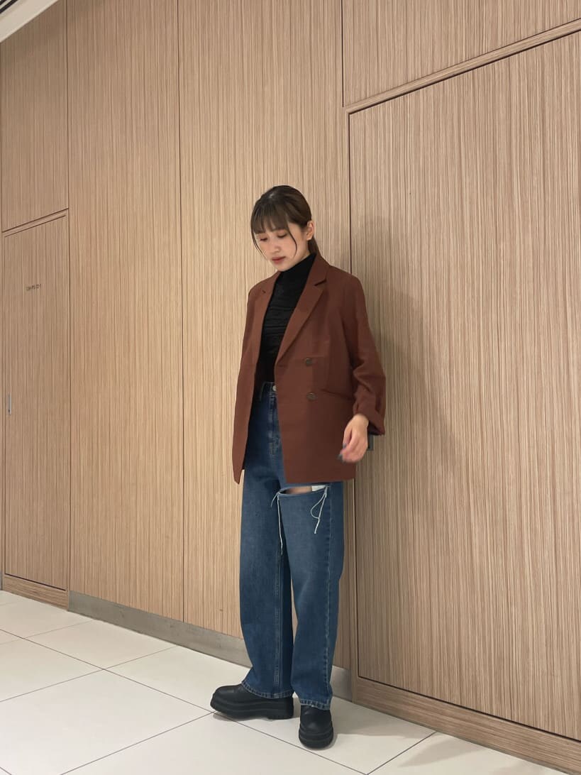 ブラウン系のテーラードジャケット、ブルー系のデニムパンツ、ブラック系のニット/セーターを着用したレディースの夏コーディネートの3枚目の写真